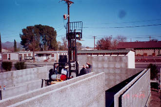 11/29 14:25 Lowering 2-Couse section into position with use of forklift.  After bonding two courses at ground level a forklift is used to place on top of wall eliminating the use of scaffolding.